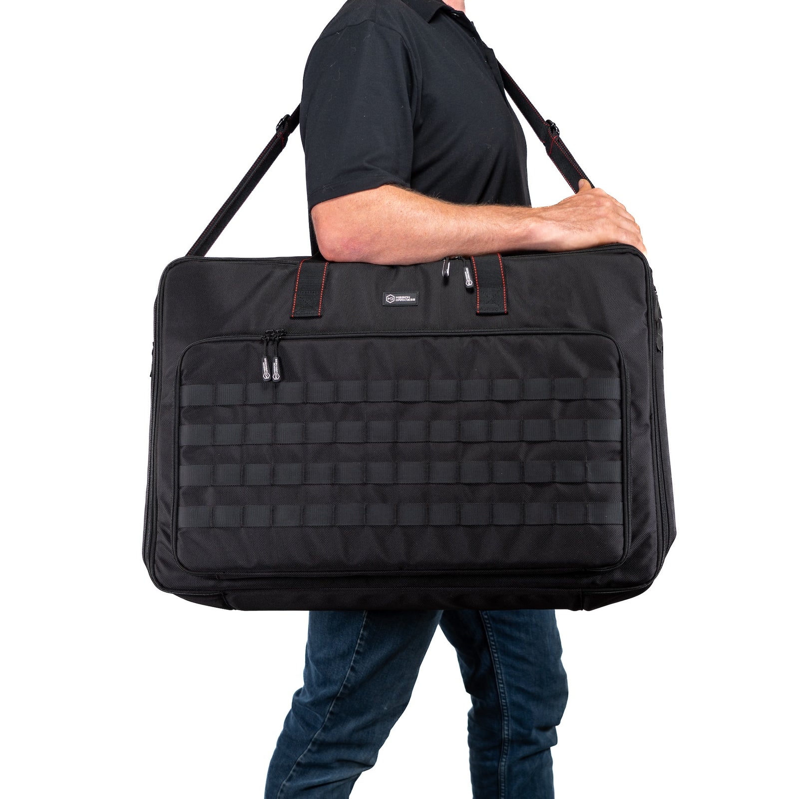 Person carrying the collapsed BlockBox Touch Pro in its padded case by the shoulder strap