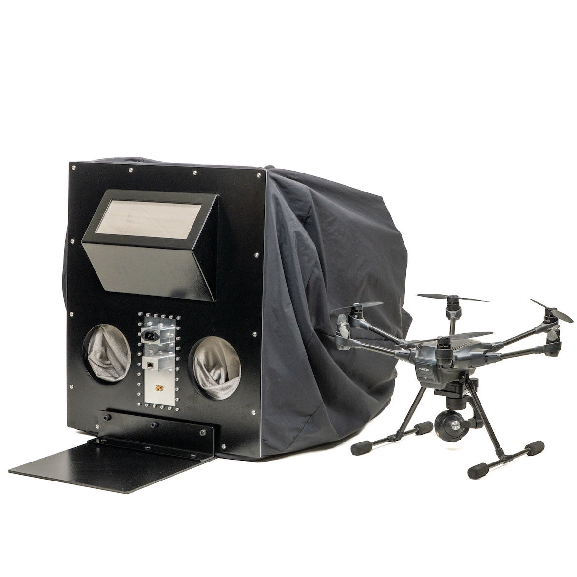 Drone Ops Rapid Cinch enclosure with interface plate and viewing window, shown beside a hexacopter drone