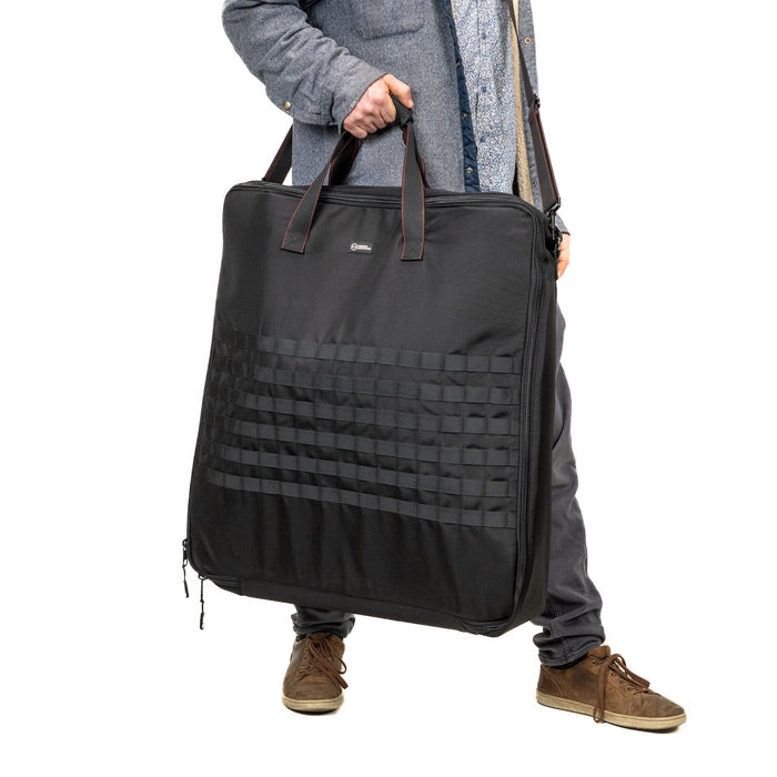 Operator carrying the Rapid Cinch padded carrying case by its handles