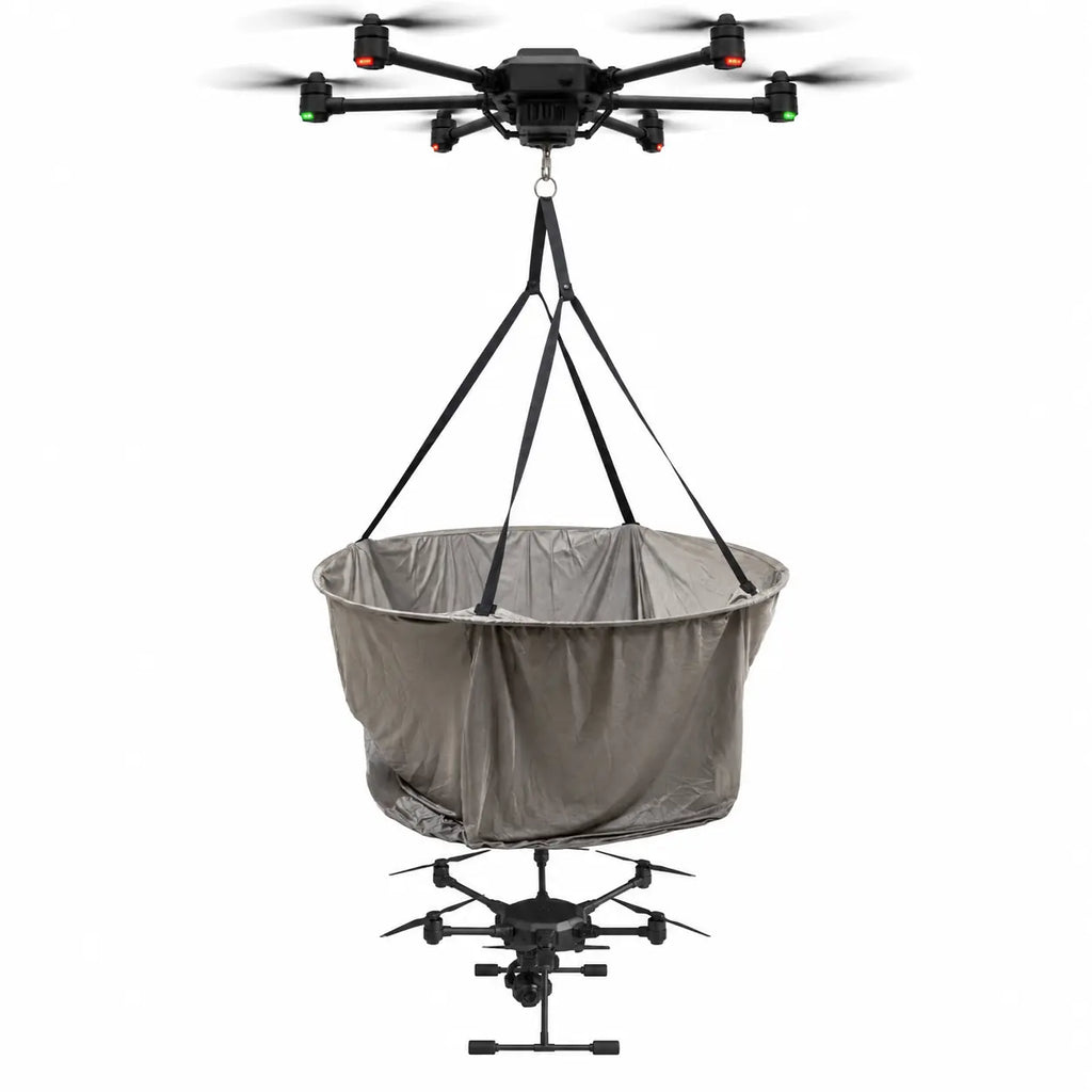 Heavy-lift carrier drone suspending the DroneCloak by its webbing straps and lowering it over a target drone